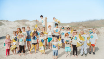 The Sea Pines Beach Clean Up Crew, made up of more than a dozen kids, stands proudly on Sea Pines Beach, where they work to keep the coast clean.