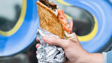 A hand holds a gyro from Eirinis Gyros & More in Corpus Christi, Texas
