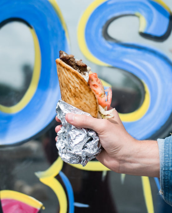A hand holds a gyro from Eirinis Gyros & More in Corpus Christi, Texas