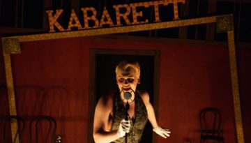 An actor on stage performing a scene in the production of Cabaret at Aurora Arts Theatre in Corpus Christi