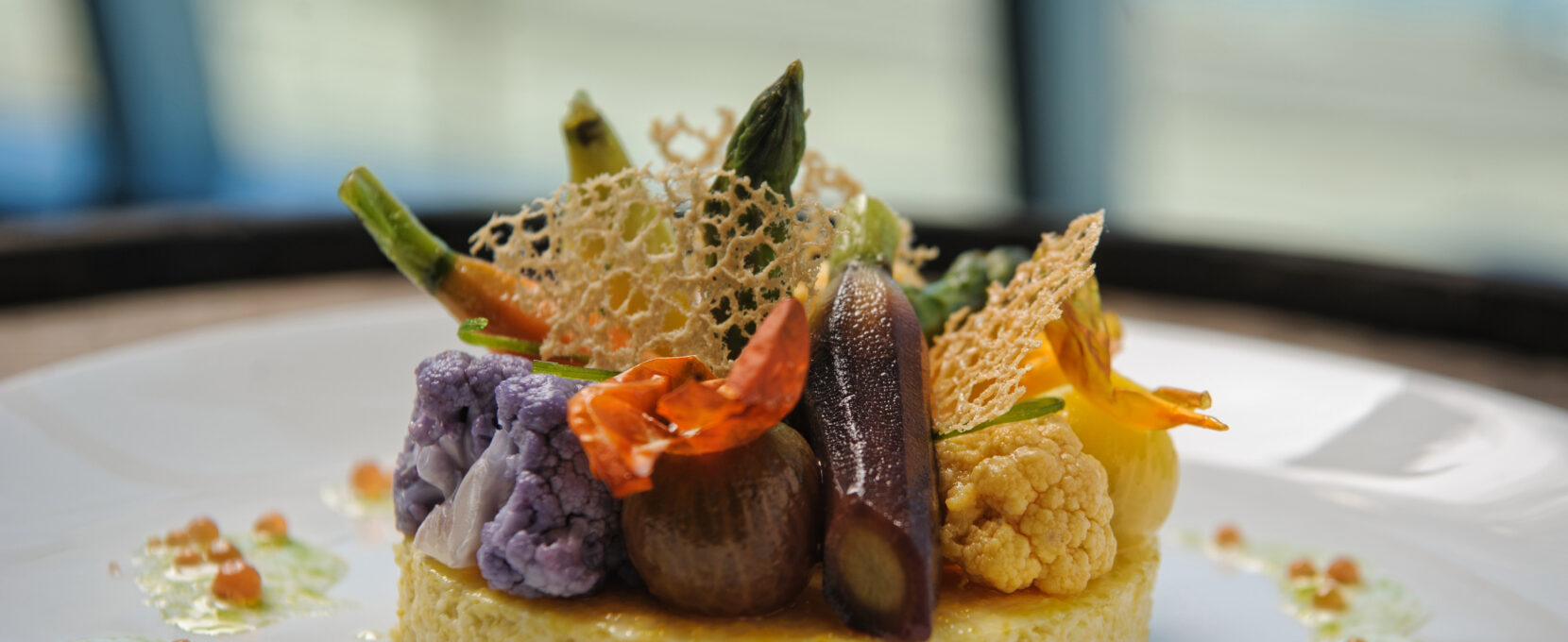 Venue by the Bay serving Smoked Corn Cake & Poached Heirloom Vegetables, corn “milk”, chive oil, tomato caviar, and roast garlic tuille at the American Bank Center.