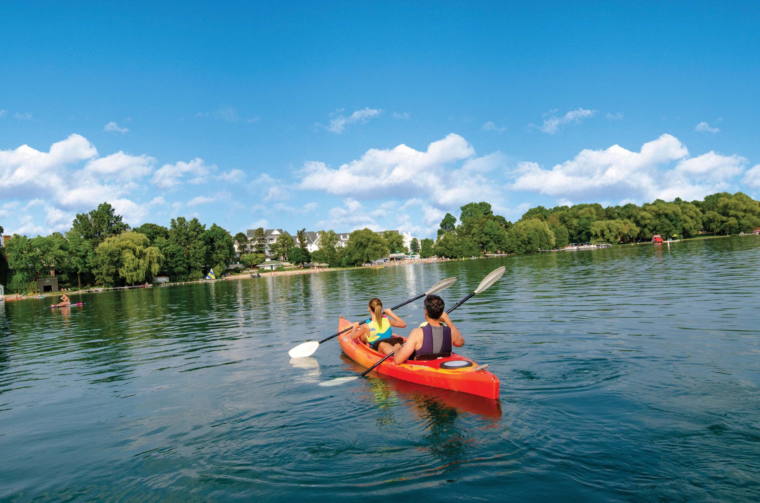 Kayakers enjoy sunny, clear weather on the calm Elkhart Lake.