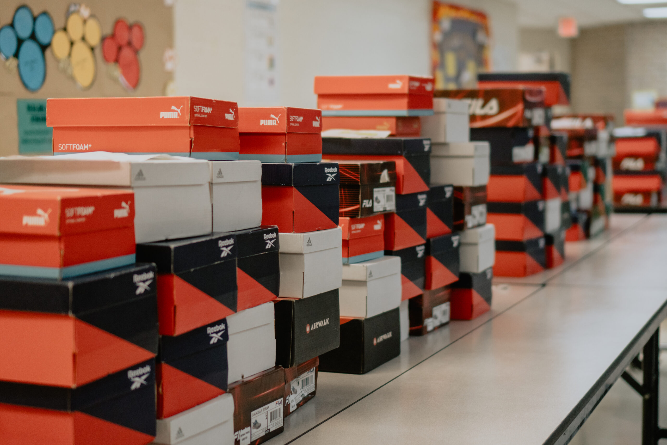 Stacks of children's shoes sit on the cafeteria table of T.G. Allen Elementary School in Corpus Christi just before they were gifted to each student by Fish for Life.