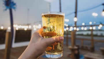 A hand holding a beer from Nueces Brewing and Barbecuing in Corpus Christi, Texas.