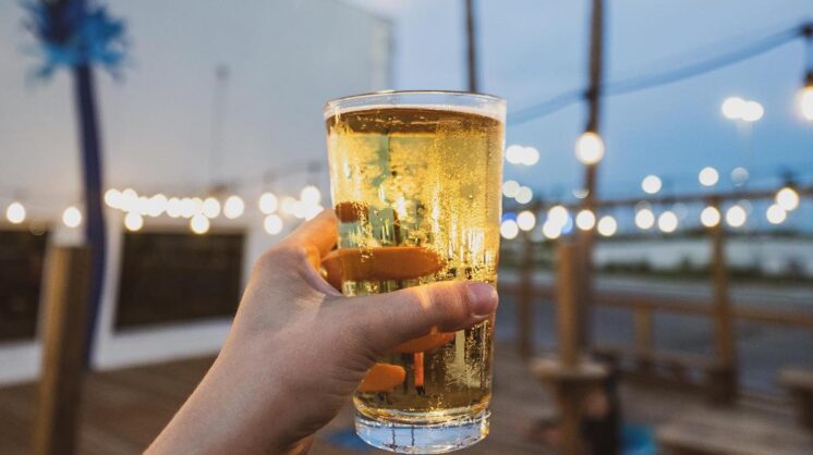 A hand holding a beer from Nueces Brewing and Barbecuing in Corpus Christi, Texas.