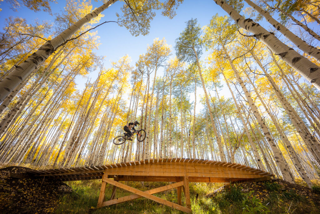 A biker rides across a bridge in Snowmass, Colorado, the perfect location for a fall vacation.