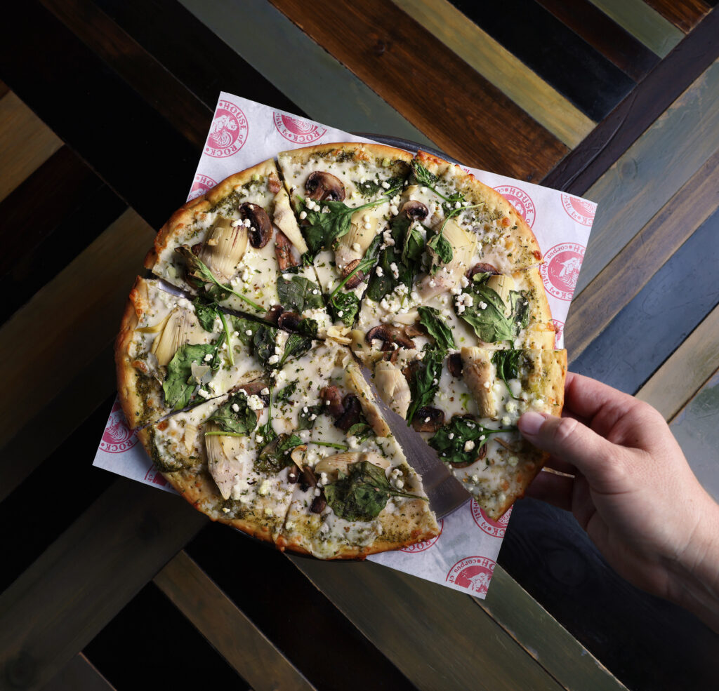 A hand pulls out a slice of House of Rock's Earth Day Pie.