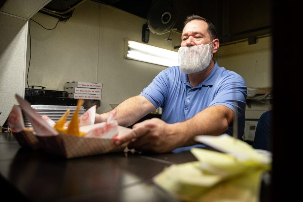 Casey Lain serves tamales at the annual Christmas Eve Tamale Dinner at House of Rock. 