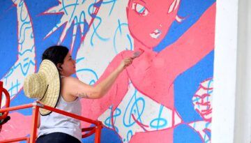 Artist painting one of five new murals in downtown Corpus Christi.