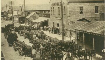 Horses line up to pull carts of pipe sold by E.H. Caldwell Hardware, corner of Chaparral and Peoples Streets Texas