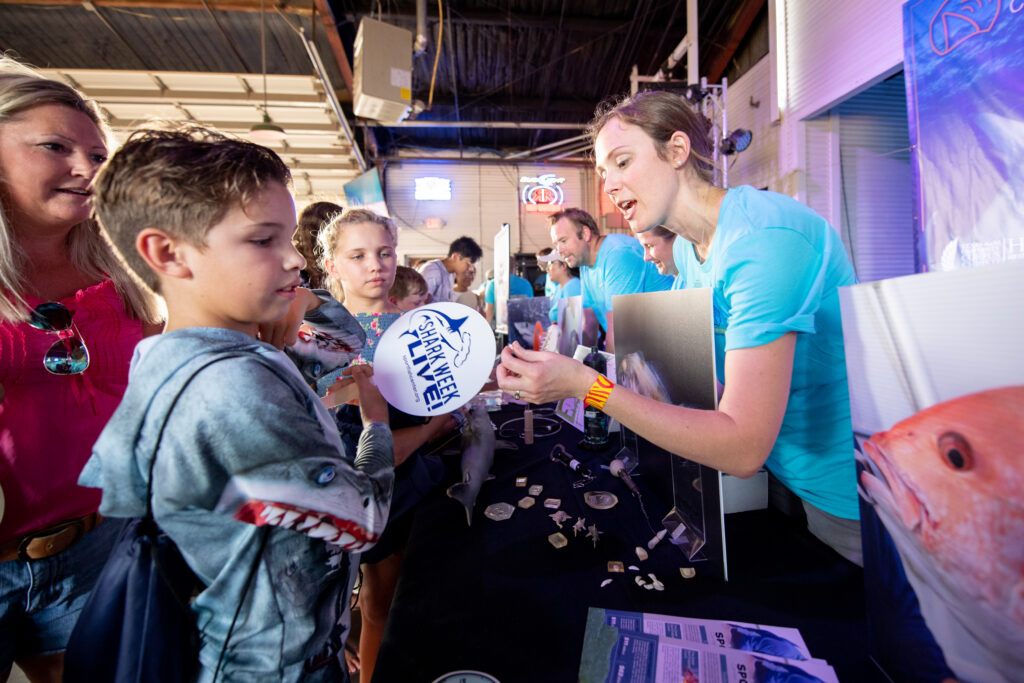 Dr. Kesley Banks hands out goodies during a Shark Week event at Brewsters Street in Corpus Christi, Texas.