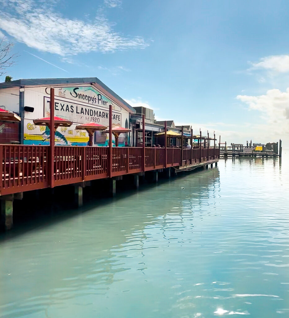 A wide shot photo of Snoopy's Pier, a seafood restaurant and bar located outside of Corpus Christi, Texas.