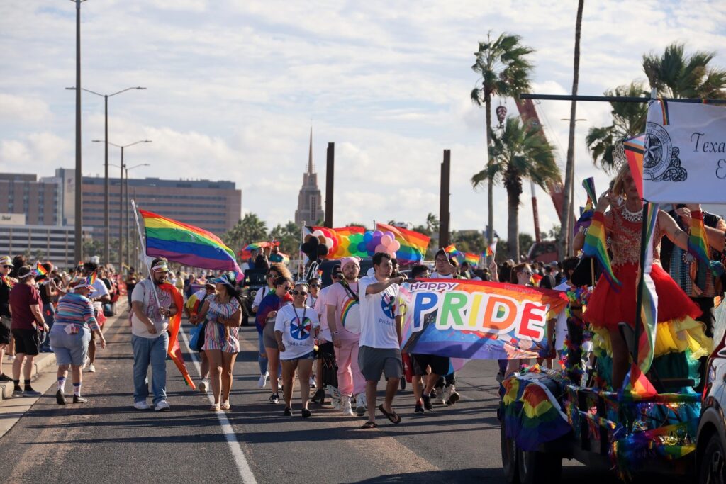 A group of people walking in the Corpus Christi Pride Parade