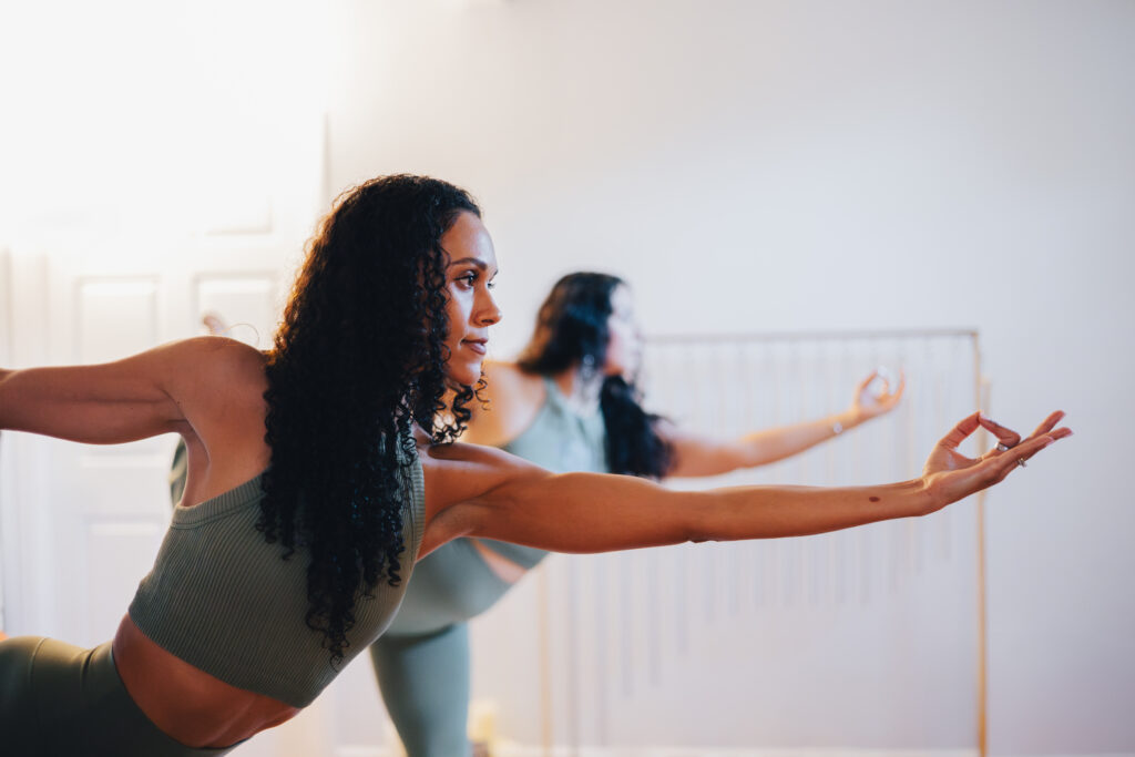 Owners of Sacred Sisters Wellness in Corpus Christi stand in a yoga pose. 