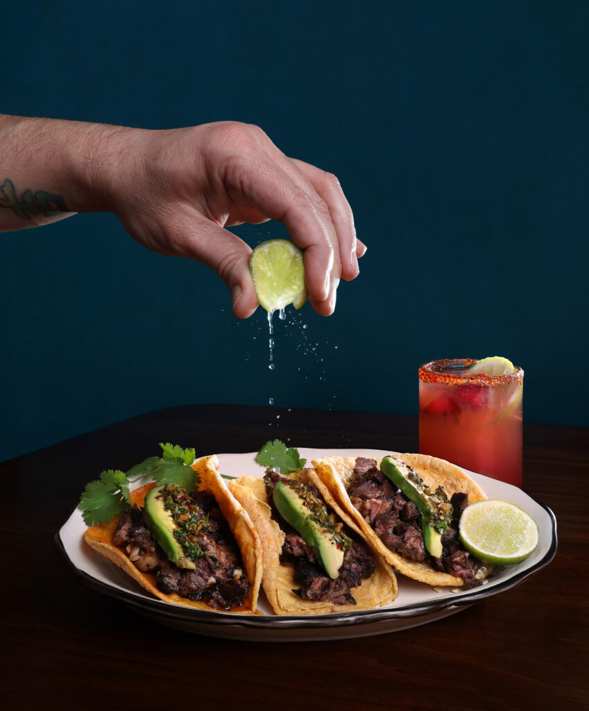 A hand squeezes a lime on a line up of tacos at El Camino in Corpus Christi.