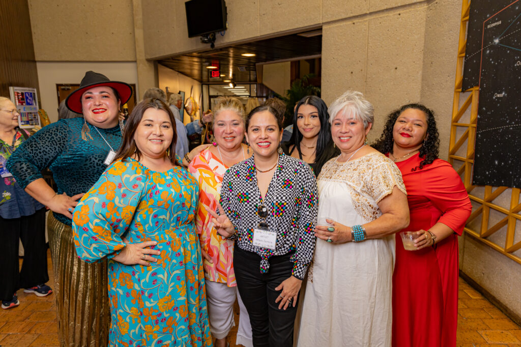 Artists Mayra Zamora and Monica Marie Garcia, along with family and friends, stand in the Weil Gallery at the La Merienda 2024 event. 