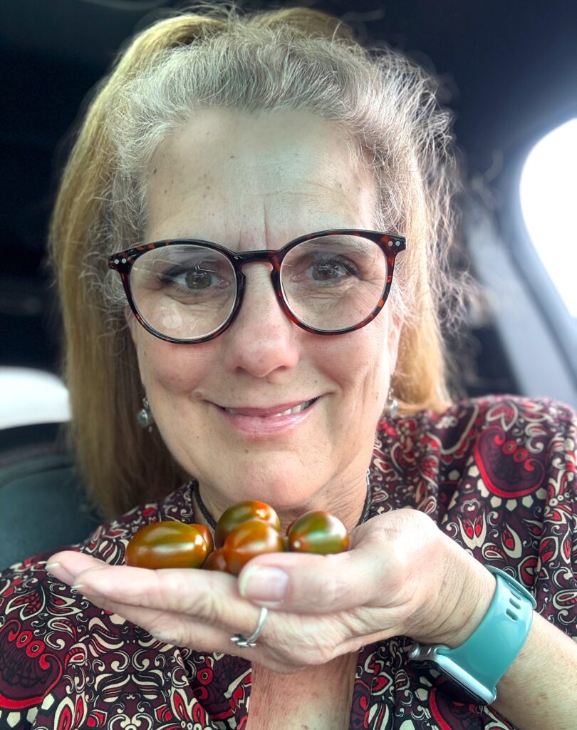 Andy with Medina Ag holds small tomatoes in her hands. 
