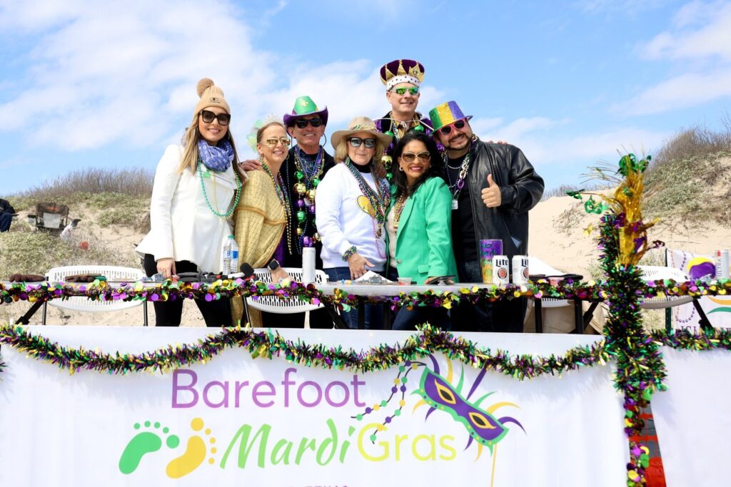 Seven people stand on a float at the annual Barfoot Mardi Gras Parade in North Padre Island, Corpus Christi, Texas.