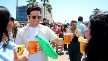 A man and friends conversing while holding beers at Picklefest in Corpus Christi.