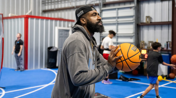 Jacolby Satterwhite shoots a basketball inside his training center, Supreme Athletics Training Center.