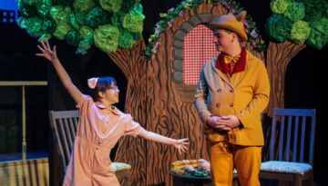 Two kids performing on stage at the Aurora Arts Theatre Summer Camp.