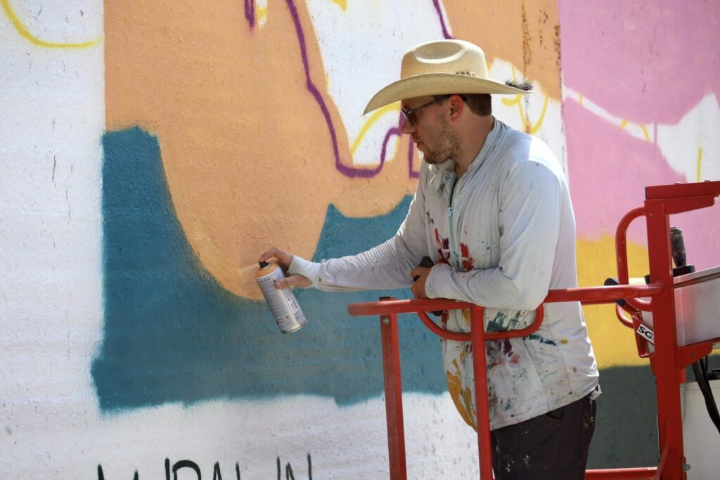 Graham Carraway paints a mural in Downtown Corpus Christi for Mural Fest 2025.