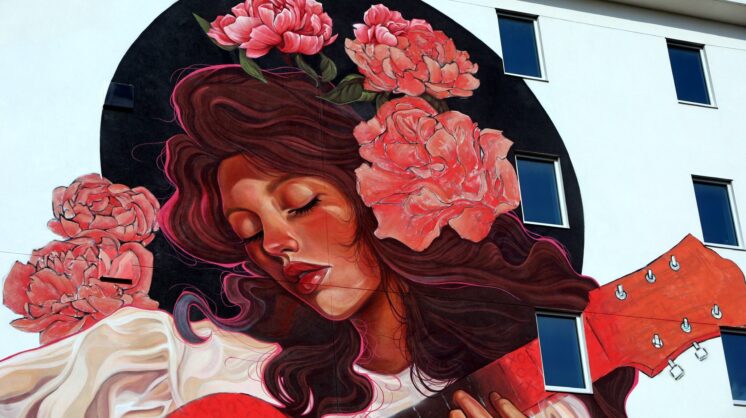 Mandi Caskey aka Miss Birdy, paints a female musician for Mural Fest 2025 in Downtown Corpus Christi.
