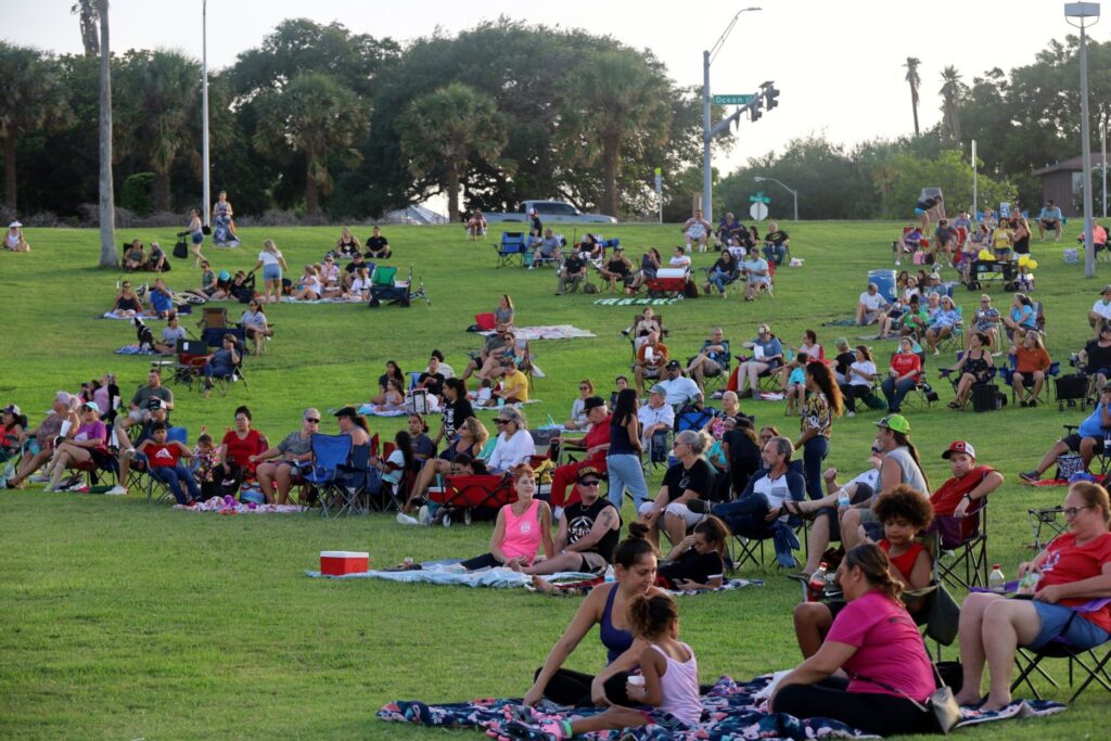 A crowd of people sitting in the park at Bay Jammin Cinema Series in Corpus Christi, Texas.