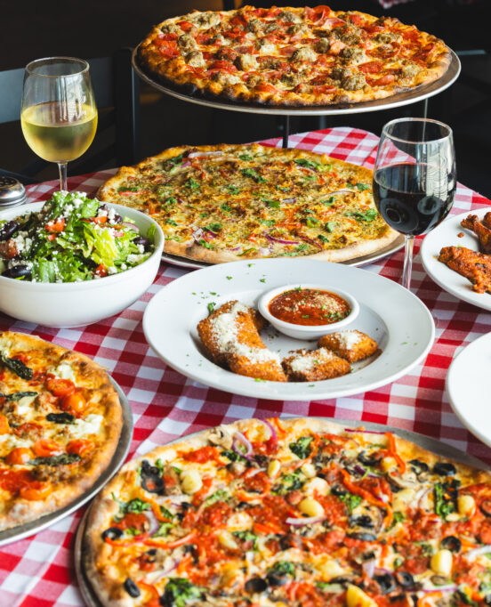 A spread of pizza and other dishes at Mozzafiota Pizza.