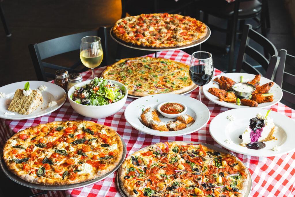A spread of pizza and other dishes at Mozzafiota Pizza.