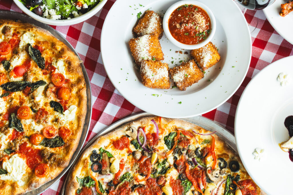 A spread of pizza and other dishes at Mozzafiota Pizza.