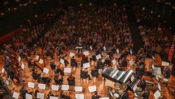 An aerial view of the Corpus Christi Symphony Orchestra performing on stage.