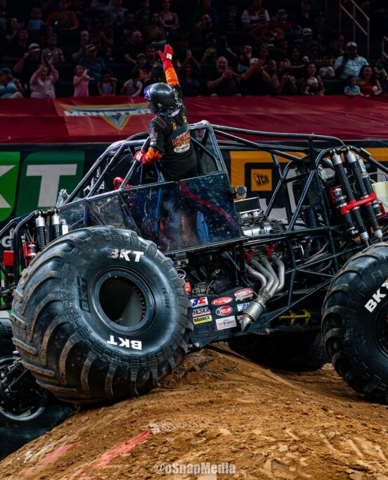 Berto Treviño sticks out of his Monster Jam truck Monster Mutt Rottweiler inside the arena.