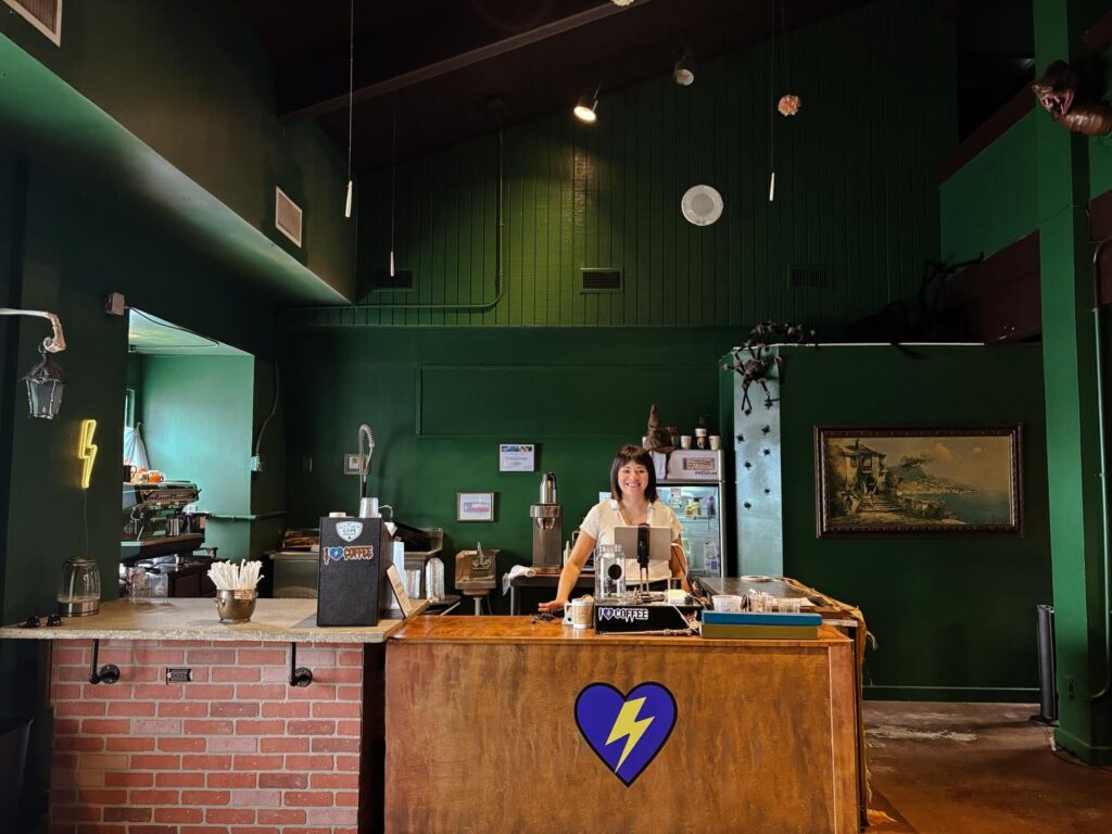 The owner of The Coffee MUGG stands behind the counter in its new location. 