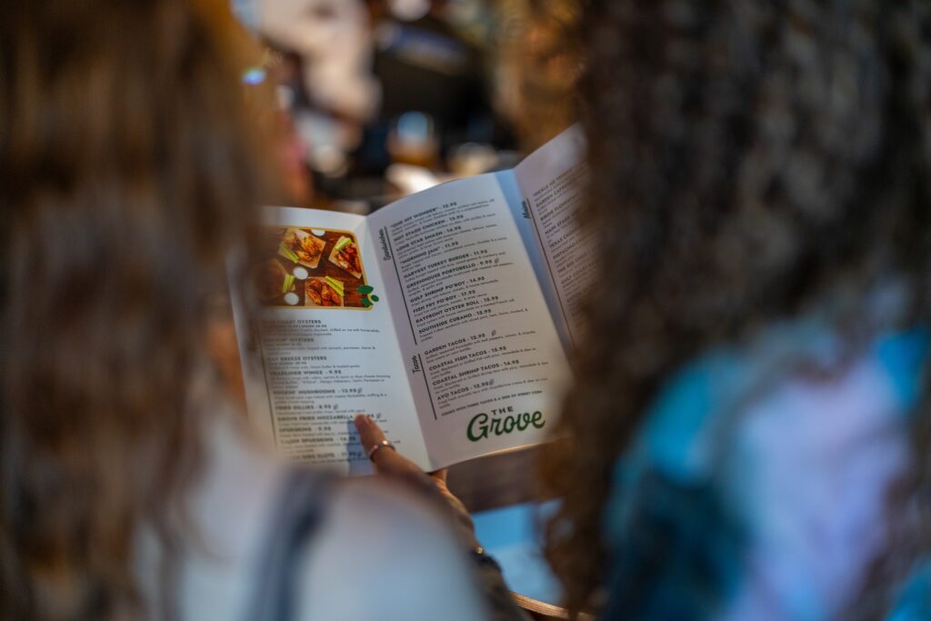 Two women photographed fro behind, holding a menu at The Grove in Portland, Texas. 