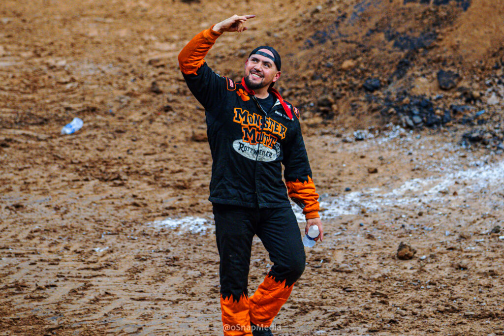 Monster truck driver Berto Treviño smiles and pumps his fist inside the Monster Jam arena.