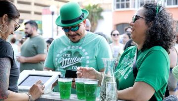 Two people buying green beer at the St. Paddy's Festival in downtown Corpus Christi.