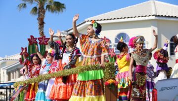 A group of young folklorico dancers wave to the crowd from a float during the annual Buc Days Children's Parade.