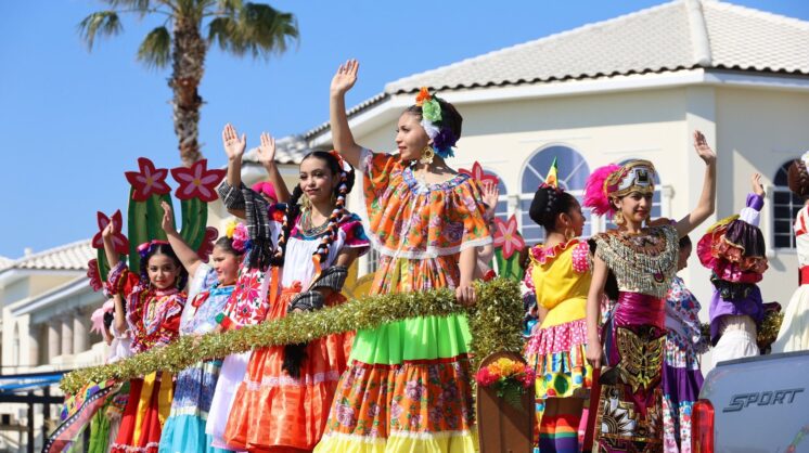 A group of young folklorico dancers wave to the crowd from a float during the annual Buc Days Children's Parade.