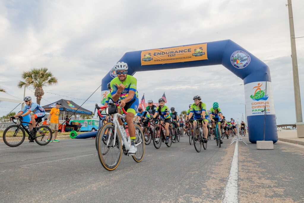 A man poses for the camera as he bikes by during Endurance Fest in Corpus Christi.